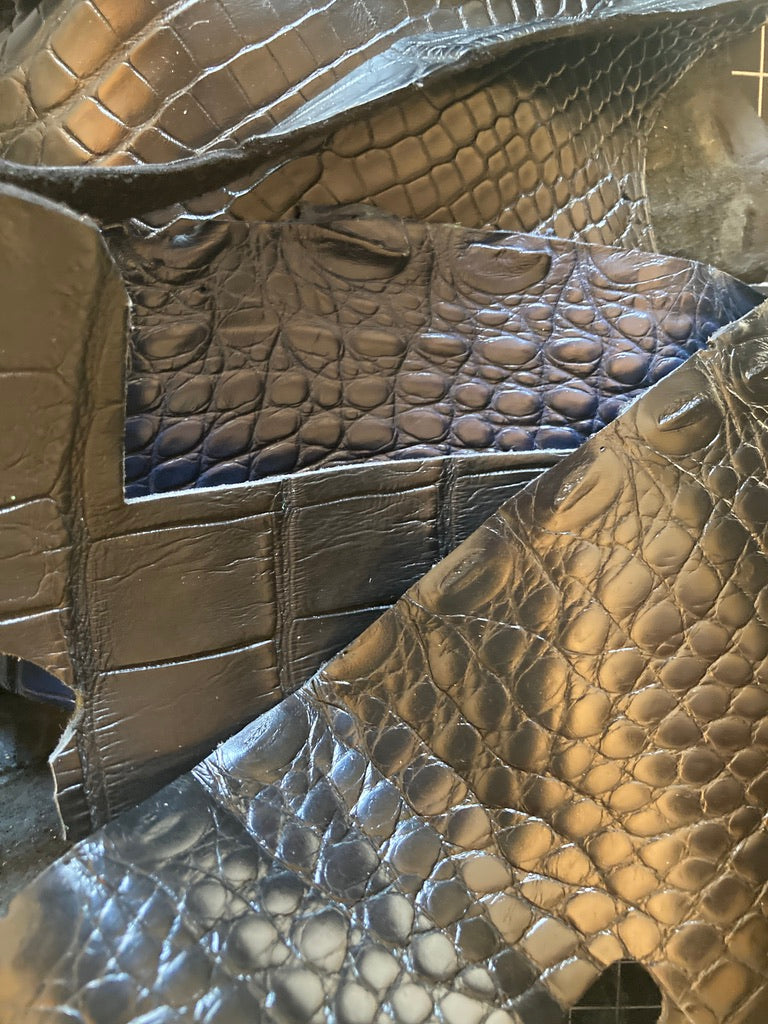 Close-up of black crocodile leather by atelier &LAB, showing natural scale pattern and premium surface texture.