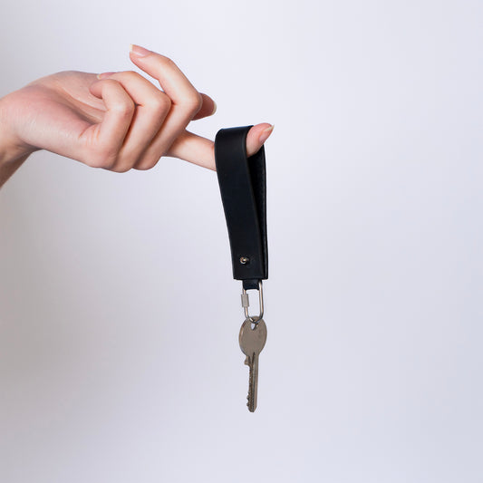 MODULE key holder by atelier &LAB — hand-held front view in black with keys, expressing a quiet luxury, minimalist leather design in premium upcycled full-grain calf leather.