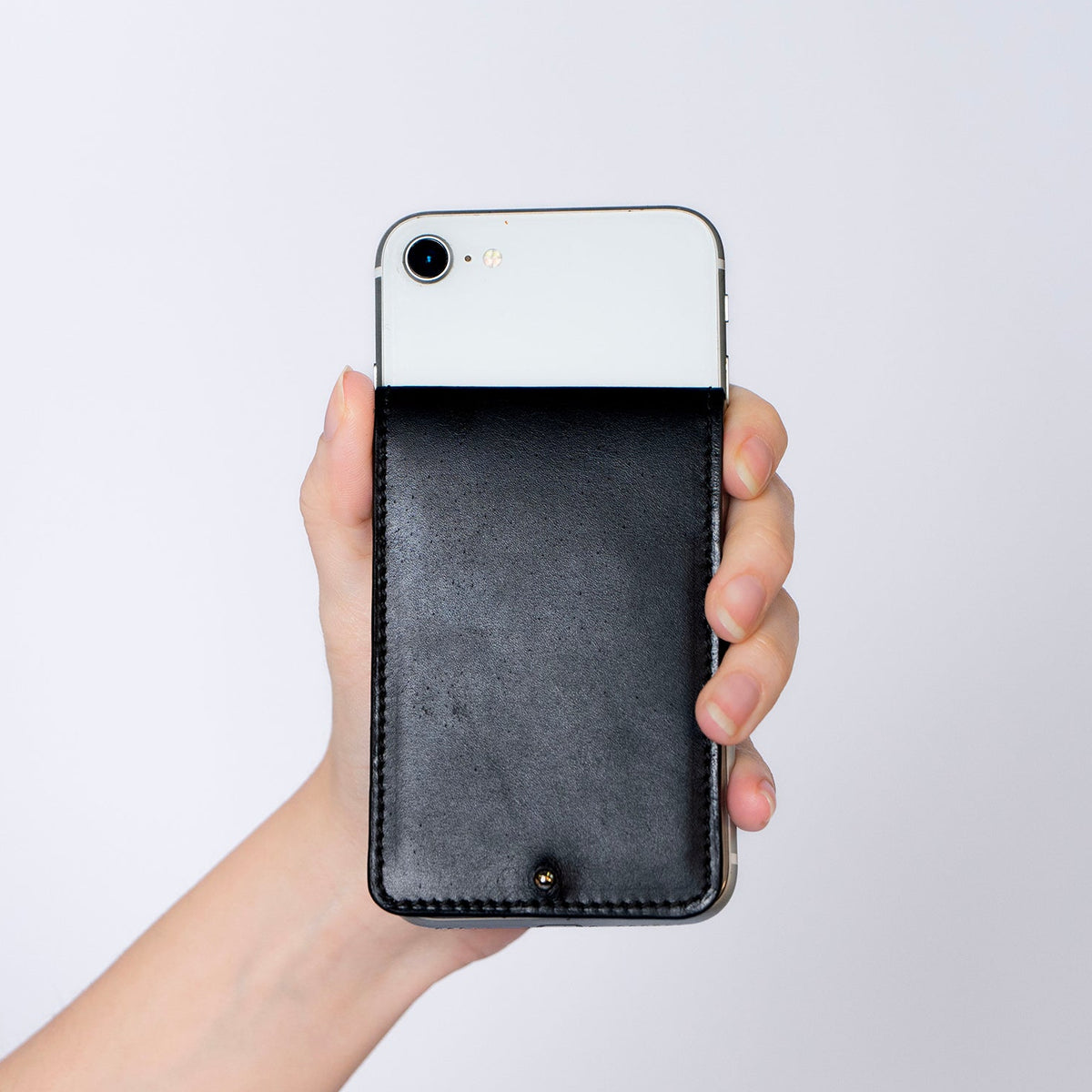 MagSafe compatible leather smartphone card holder — MODULE Pliable by atelier &LAB, black upcycled full-grain calf leather attached to iPhone, Paris design studio.