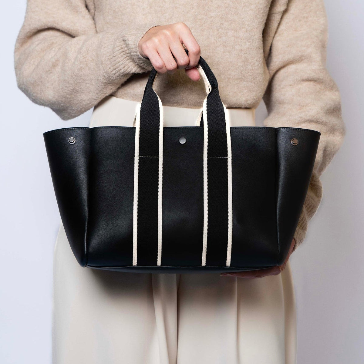 Everyday leather tote bag — NUMÉRO 03 by atelier &LAB, black upcycled full-grain calf leather, handheld front view showing an open, accessible design for daily use.