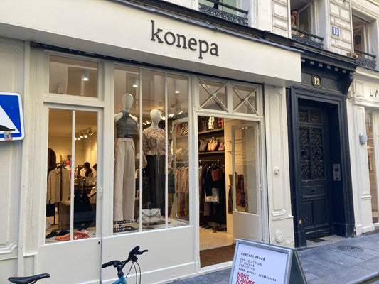 Storefront of KONEPA on Rue Montorgueil in Paris, featuring a curated selection of designer clothing and accessories, including leather goods by atelier &LAB.