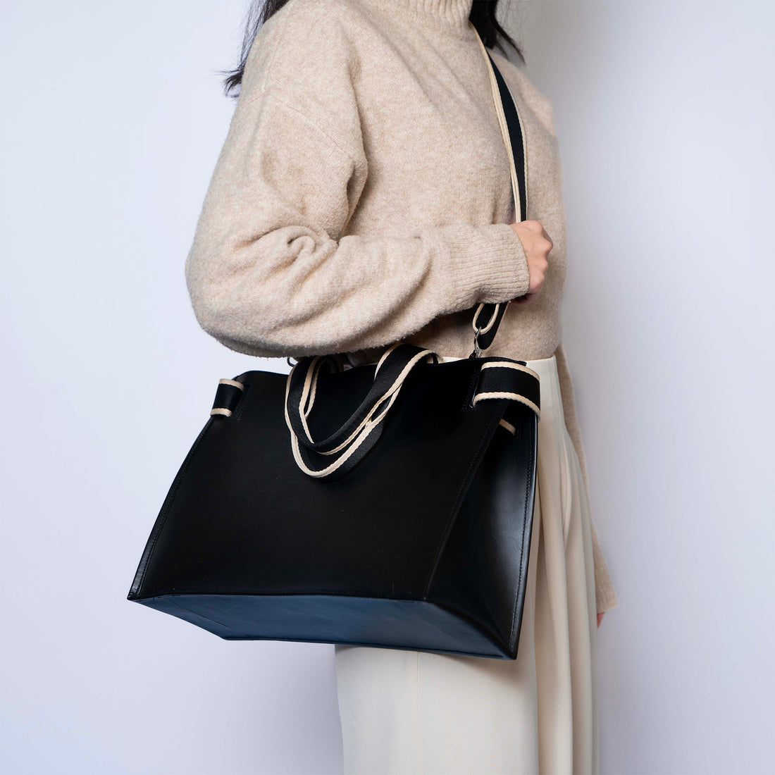 Structured leather tote bag — NUMÉRO 01 by atelier &LAB, worn on shoulder, black full-grain leather, designed to hold its shape under weight