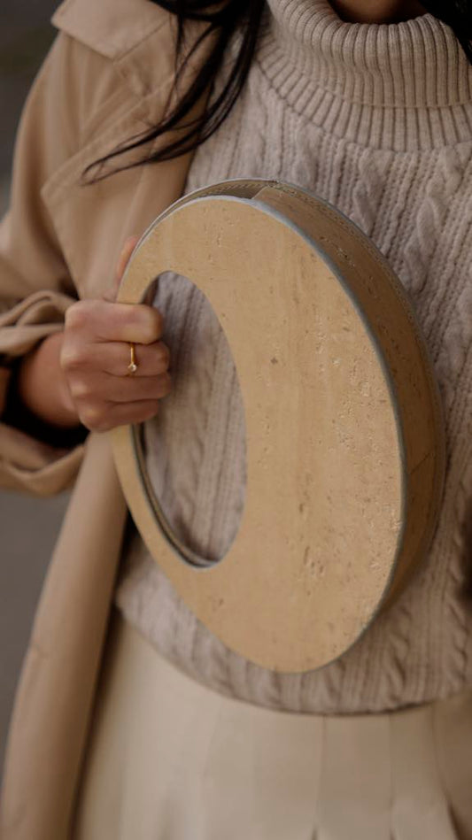 ARCHIVE 01 by atelier &LAB — mineral composite (stone-based material) ring object carried by hand at the Louvre, Paris — atelier &LAB