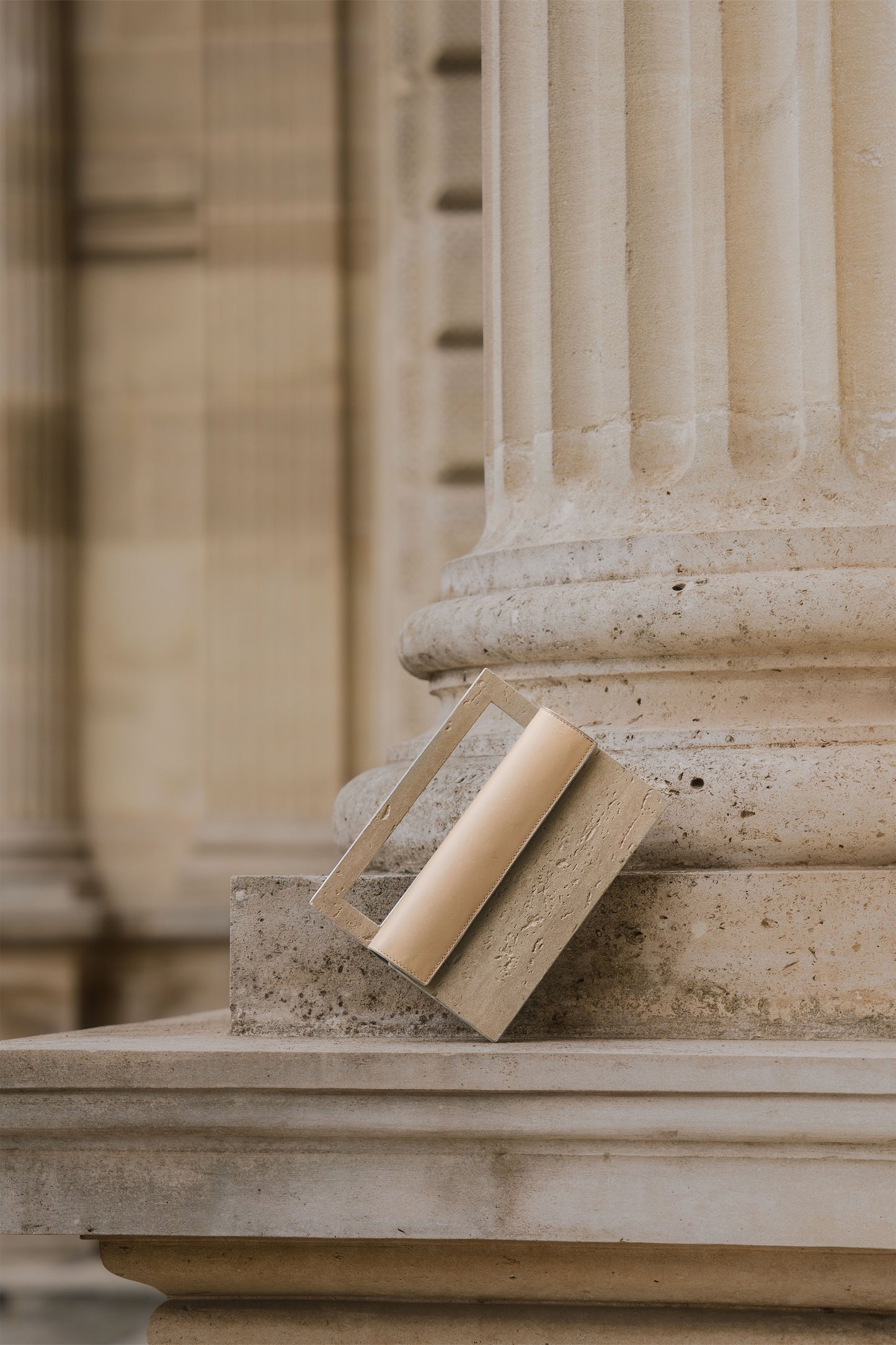 ARCHIVE 02 by atelier &LAB — rectangular Mineral Composite (stone-based material) bag with integrated mineral handle and Premium beige leather insert, presented in an editorial, Minimalist Brutalist Architectural setting, Paris.