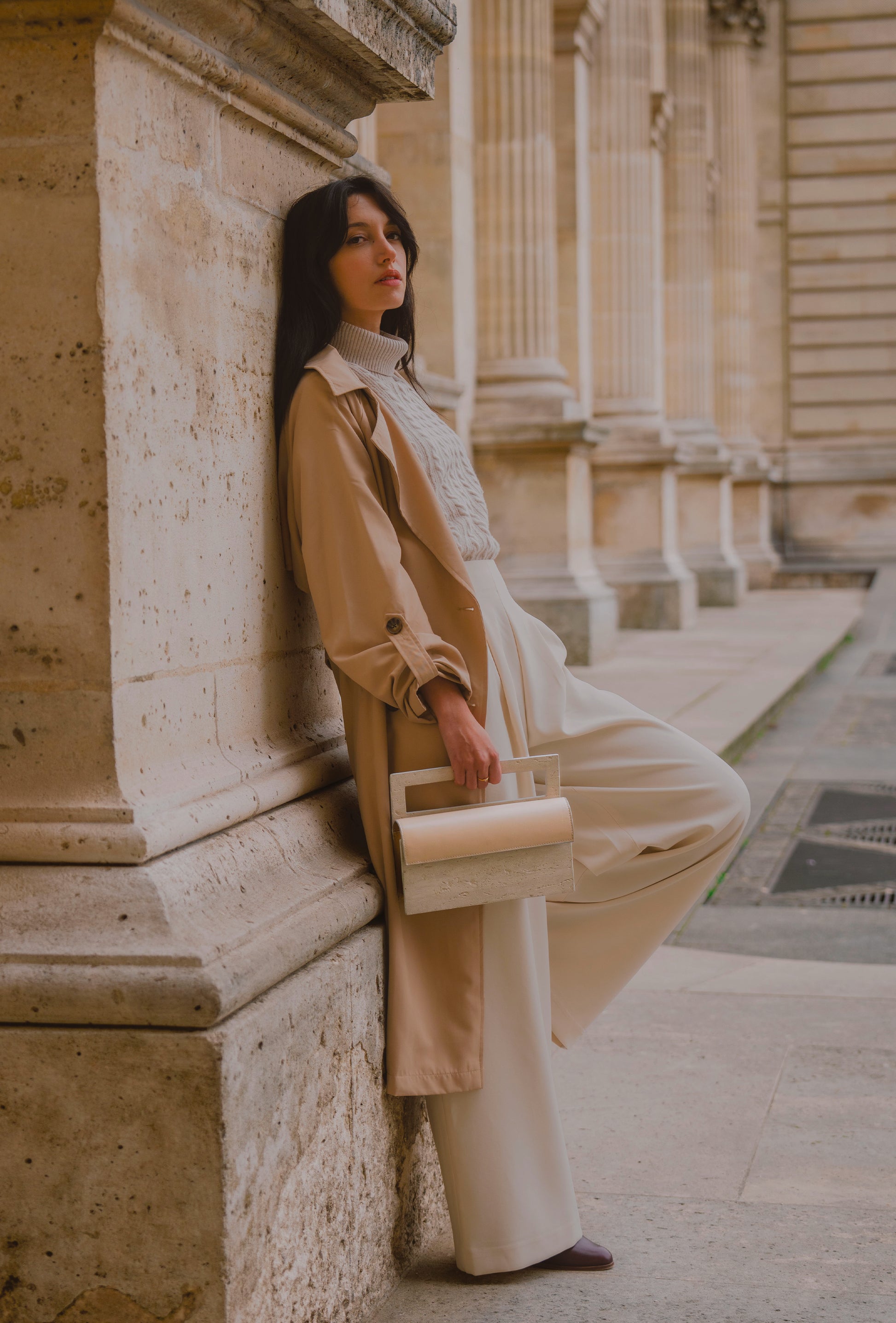 ARCHIVE 02 by atelier &LAB — rectangular Mineral Composite (stone-based material) bag with integrated Mineral handle and Premium beige leather insert, carried in a Minimalist Brutalist Architectural setting at the Louvre, Paris.