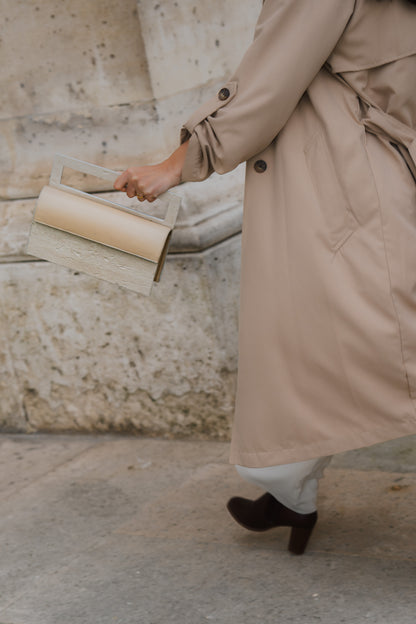 ARCHIVE 02 by atelier &LAB — editorial hand-held view in front of the Louvre, expressing quiet luxury 1hrough mineral composite architecture and premium upcycled full-grain calf leather, Paris.