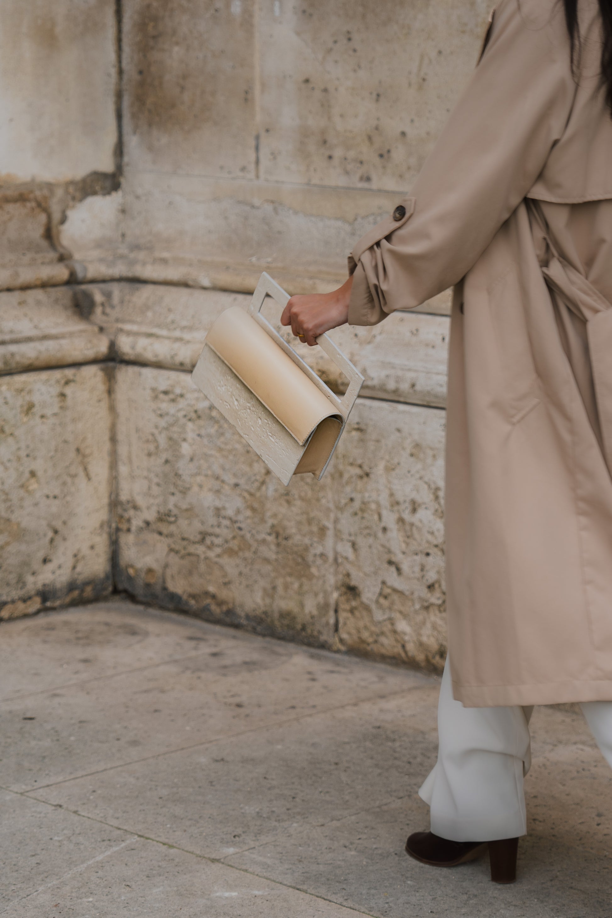 ARCHIVE 02 by atelier &LAB — rectangular Mineral Composite (stone-based material) bag with integrated Mineral handle and Premium beige leather insert, carried in a Minimalist Brutalist Architectural setting at the Louvre, Paris.