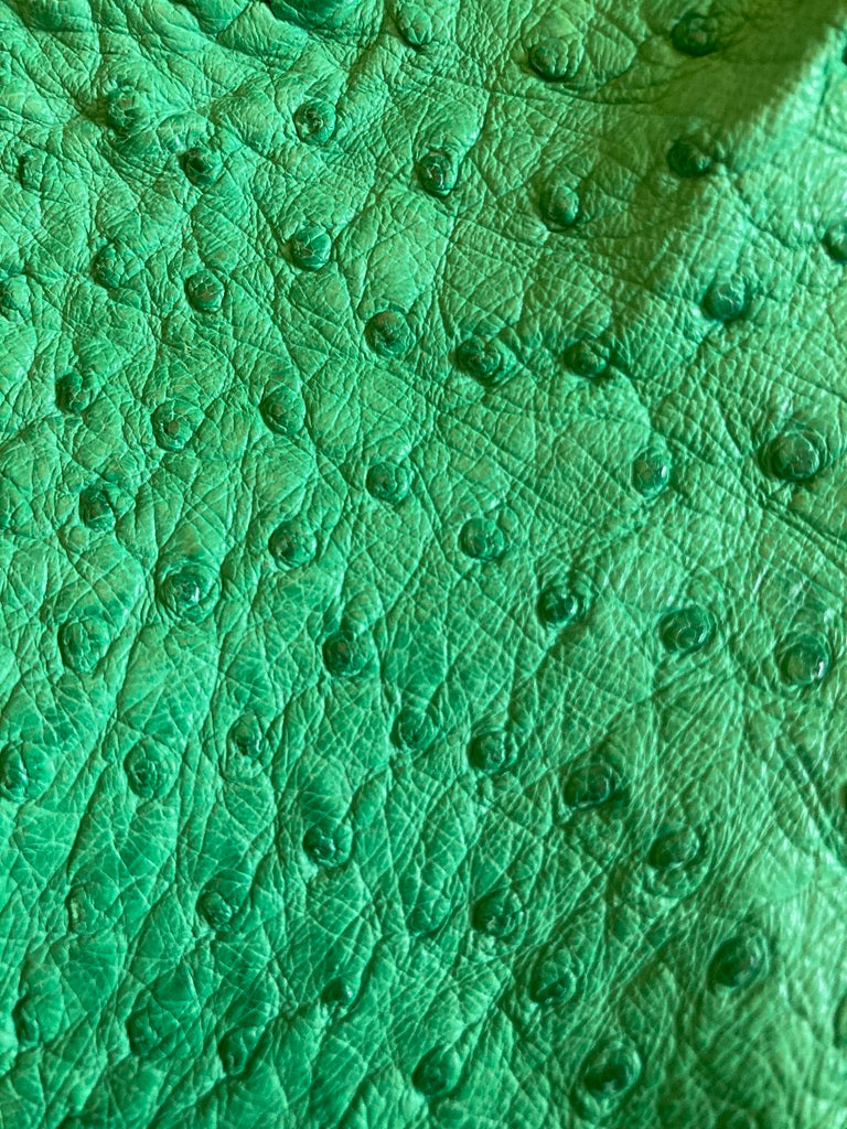Close-up of green ostrich leather texture by atelier &LAB, highlighting natural quill pattern and refined grain.