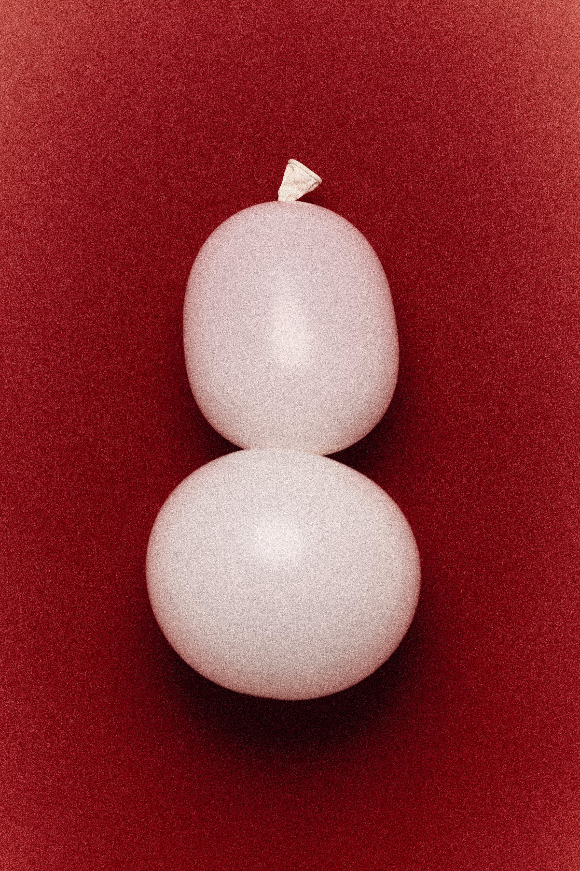 Abstract editorial composition photographed by Louis Vizet for atelier &LAB, white balloon forms on deep red background from NUMÉRO 02 visual study series
