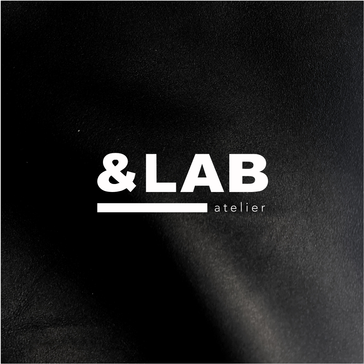 Atelier &LAB official logo embossed-style on premium black full-grain leather — Minimalist luxury craftsmanship, Paris.