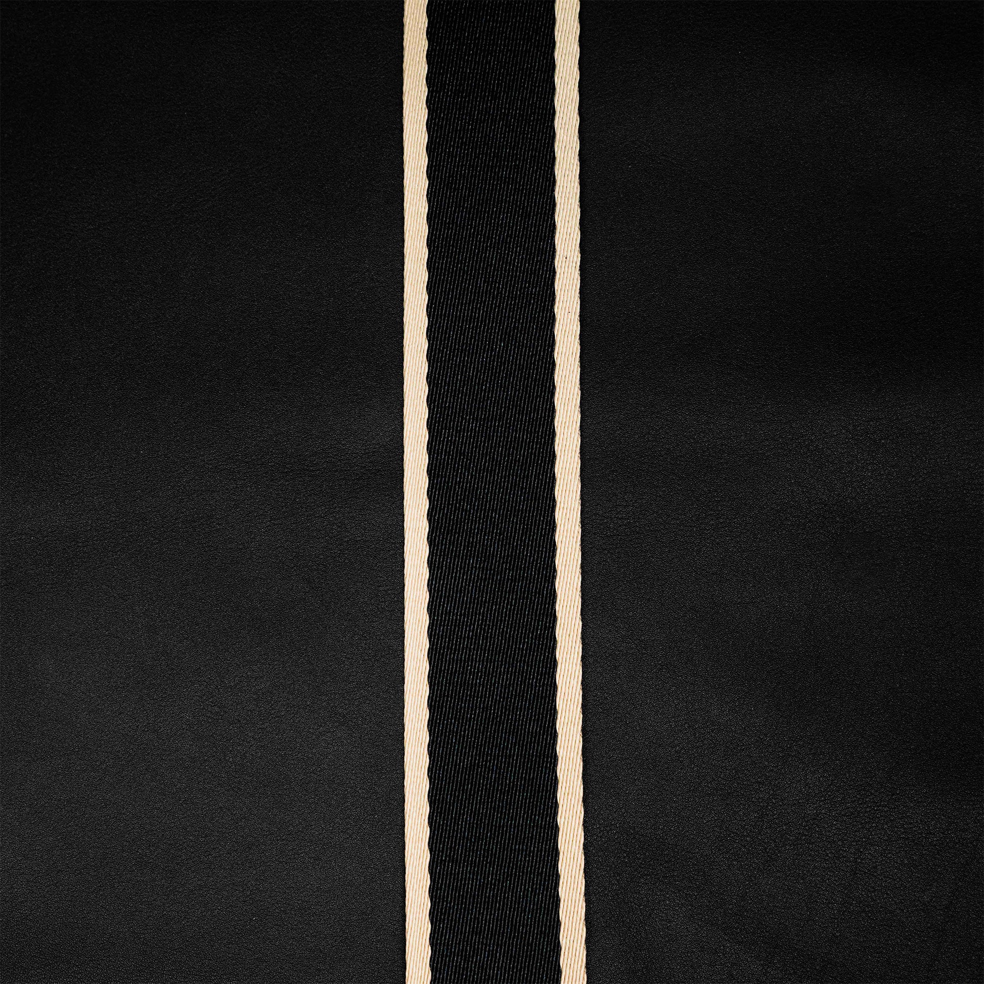 Close detail of atelier &LAB premium black upcycled full-grain calf leather paired with a technical woven polyester strap — refined material contrast.