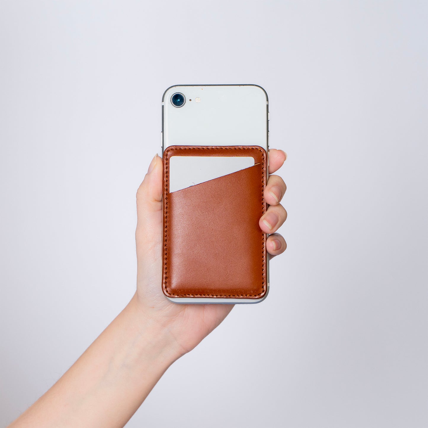 MODULE card holder simple by atelier &LAB — front view attached to iPhone, revealing a compact, architectural card holder in cognac, premium upcycled full-grain calf leather, Paris.