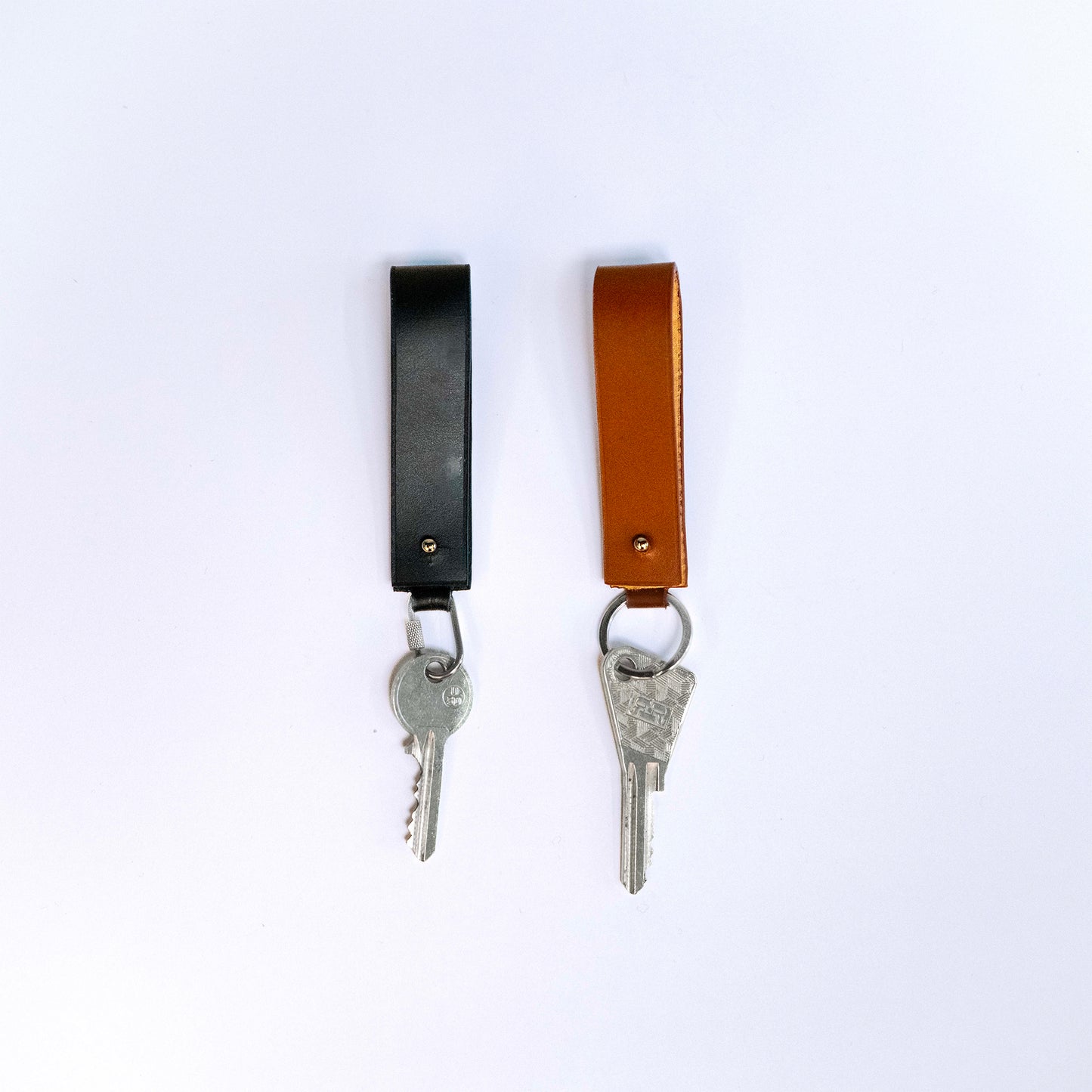 MODULE key holder by atelier &LAB — front view with keys, revealing a compact, architectural leather form in black and cognac with key ring and carabiner clip, premium upcycled full-grain calf leather.