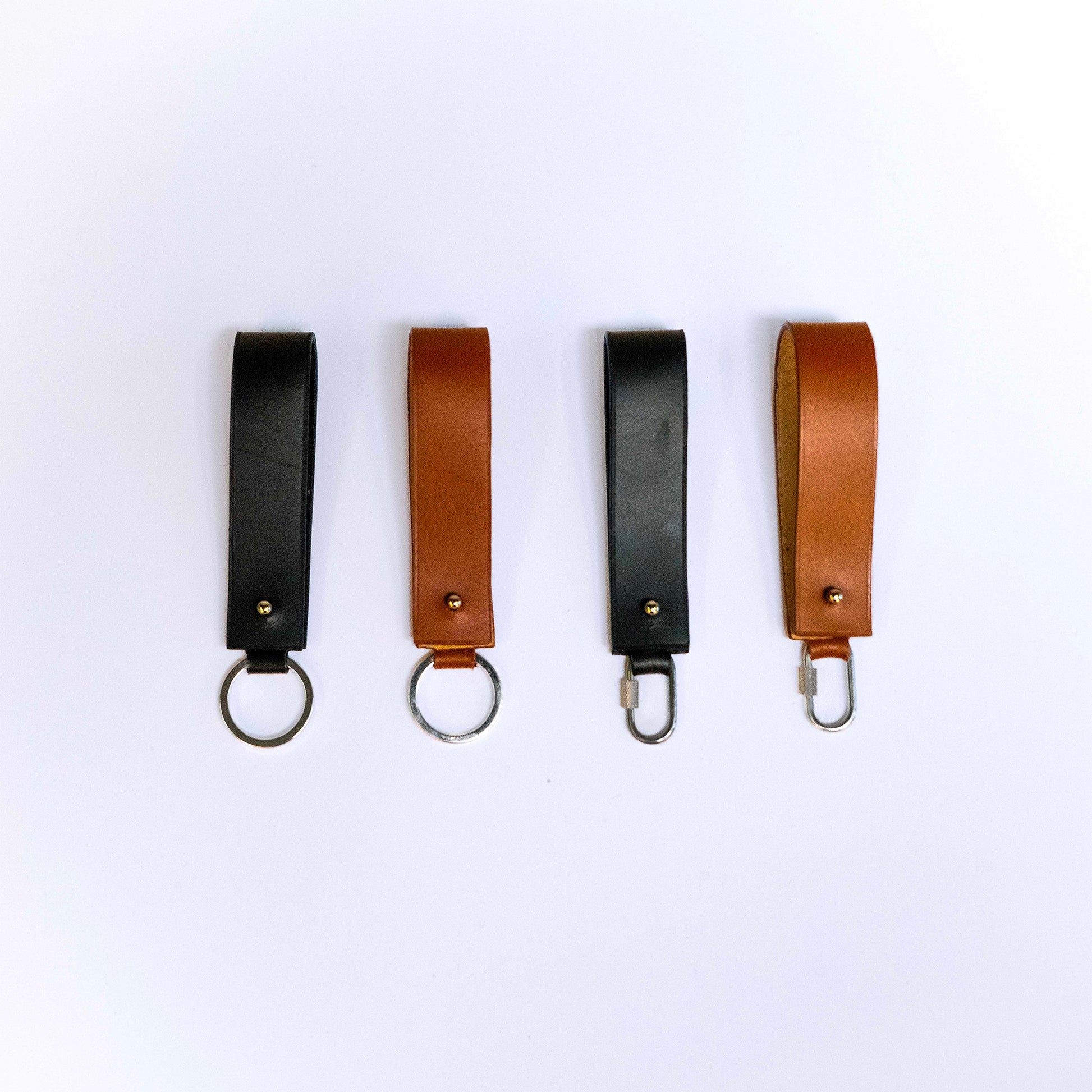 Minimal leather key holder — MODULE by atelier &LAB, black and cognac upcycled full-grain calf leather key holders shown in front view with key ring and carabiner clip, Paris design studio.