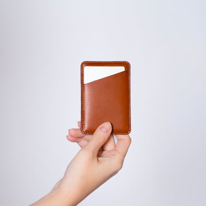 MagSafe compatible leather smartphone card holder — MODULE Simple by atelier &LAB, cognac upcycled full-grain calf leather held in hand, Paris design studio.