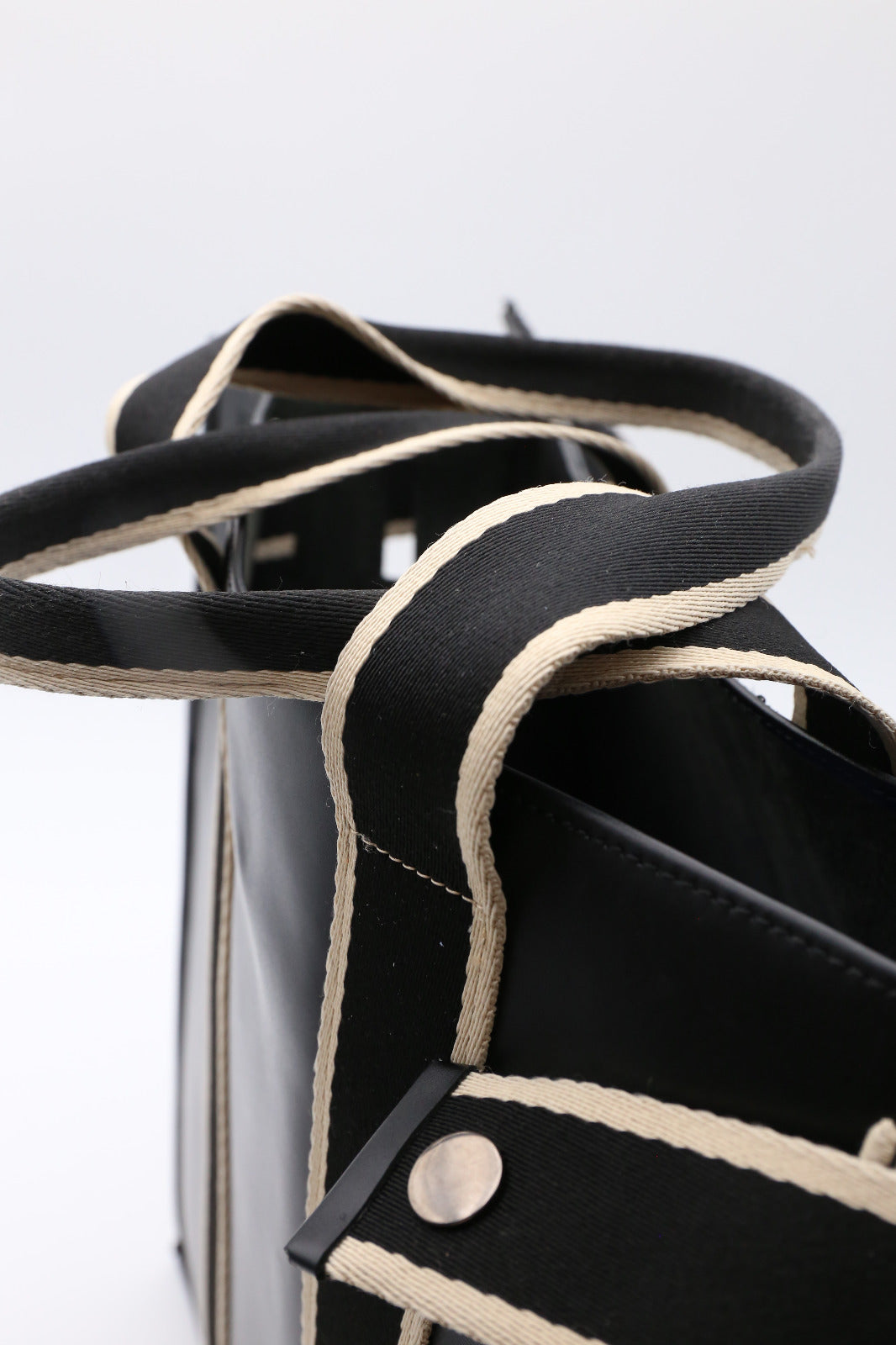 Structured leather tote bag — NUMÉRO 00 MAXI by atelier &LAB, detail view showing textile strap and leather contrast in black upcycled full-grain calf leather.