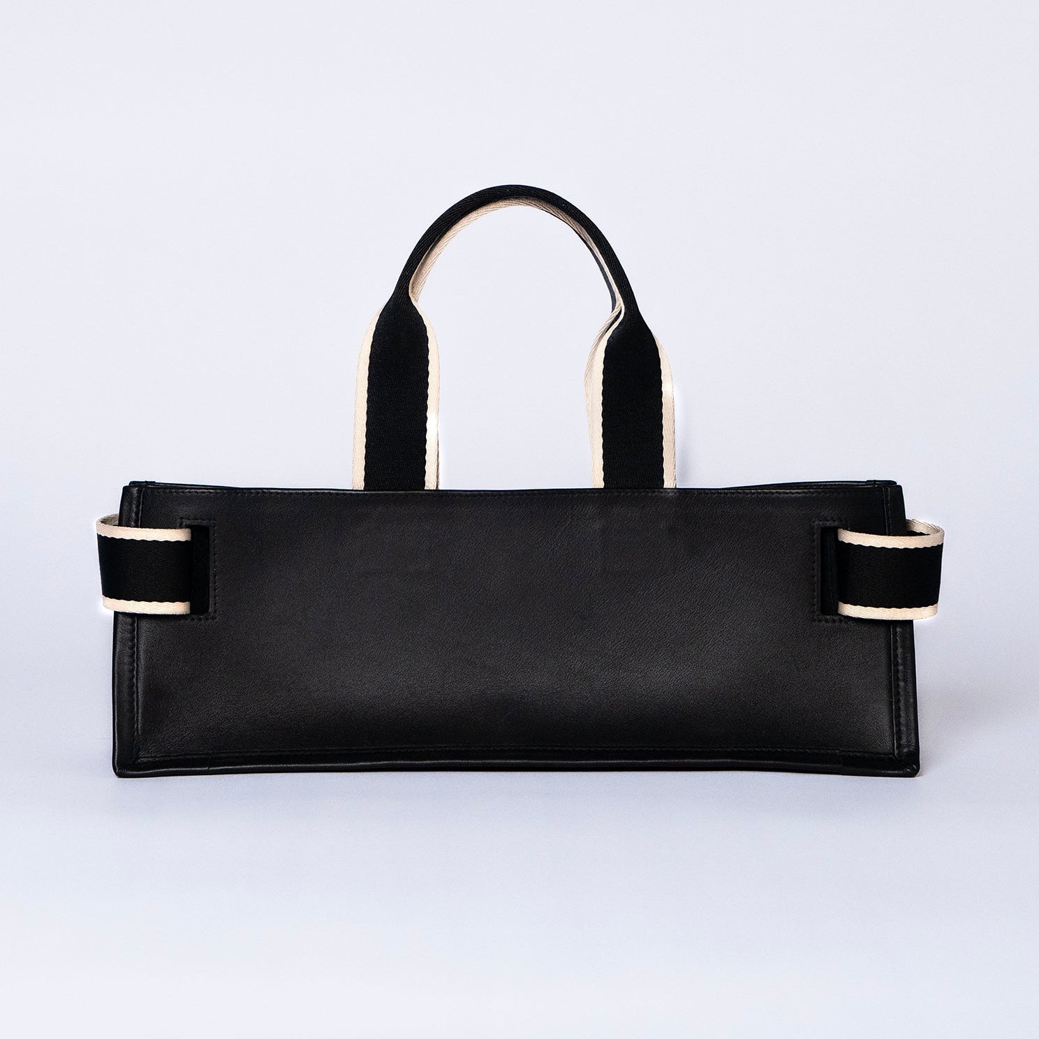 Minimal structured leather tote bag — NUMÉRO 02 PLAT by atelier &LAB, black upcycled full-grain calf leather, rear view showing a clean flat structured silhouette.