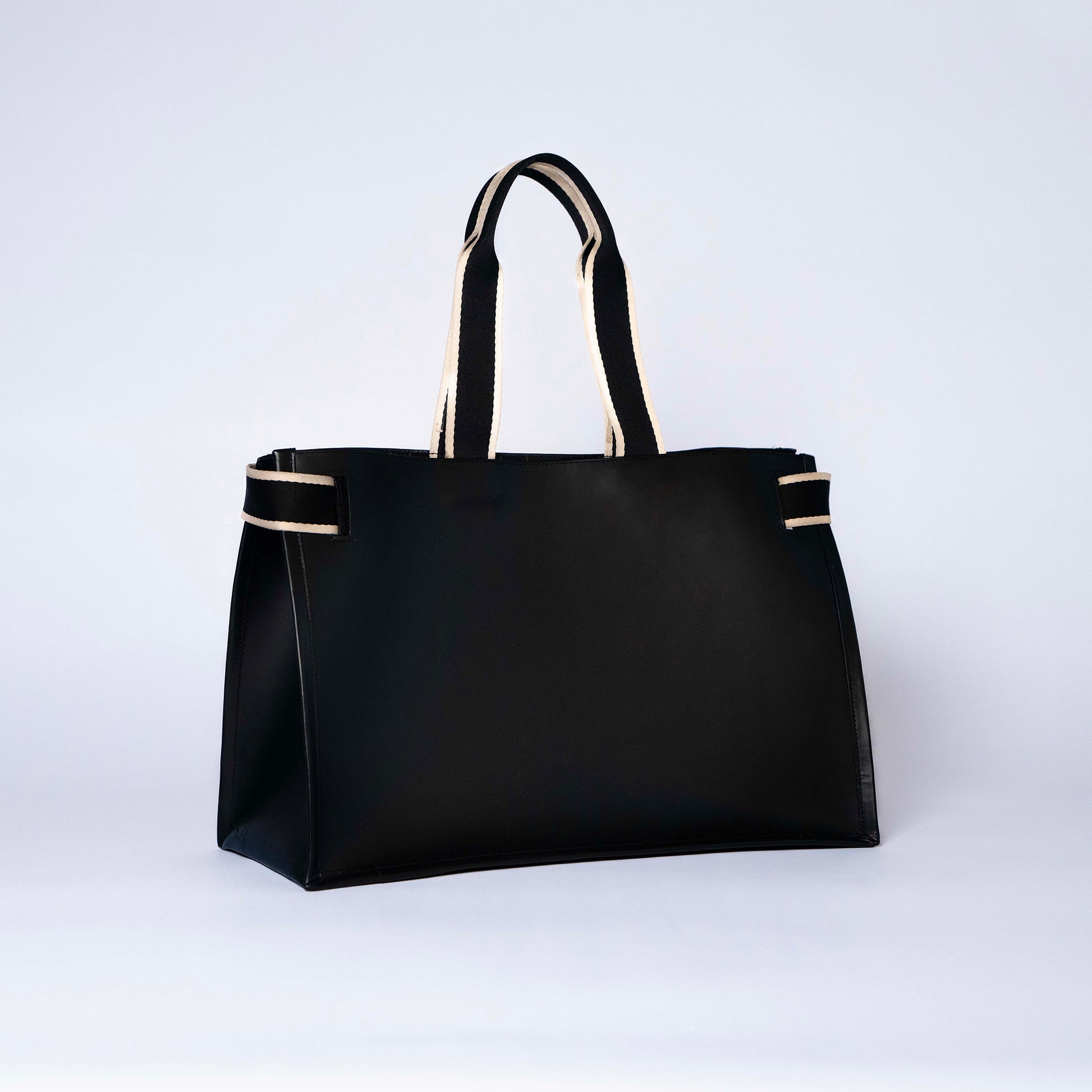 Minimal structured leather tote bag — NUMÉRO 02 by atelier &LAB, black upcycled full-grain calf leather, rear three-quarter view showing a clean, structured silhouette.