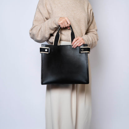 Minimal structured leather tote bag — NUMÉRO 02 by atelier &LAB, black upcycled full-grain calf leather, front view handheld showing a clean structured shape for everyday use.