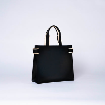 Minimal structured leather tote bag — NUMÉRO 02 by atelier &LAB, black upcycled full-grain calf leather, rear three-quarter view showing a clean, structured silhouette.