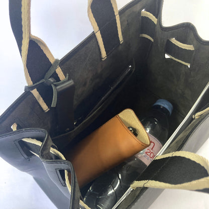 Structured leather handbag — NUMÉRO 04 M prototype by atelier &LAB, interior view showing storage capacity with essentials including bottle and small items