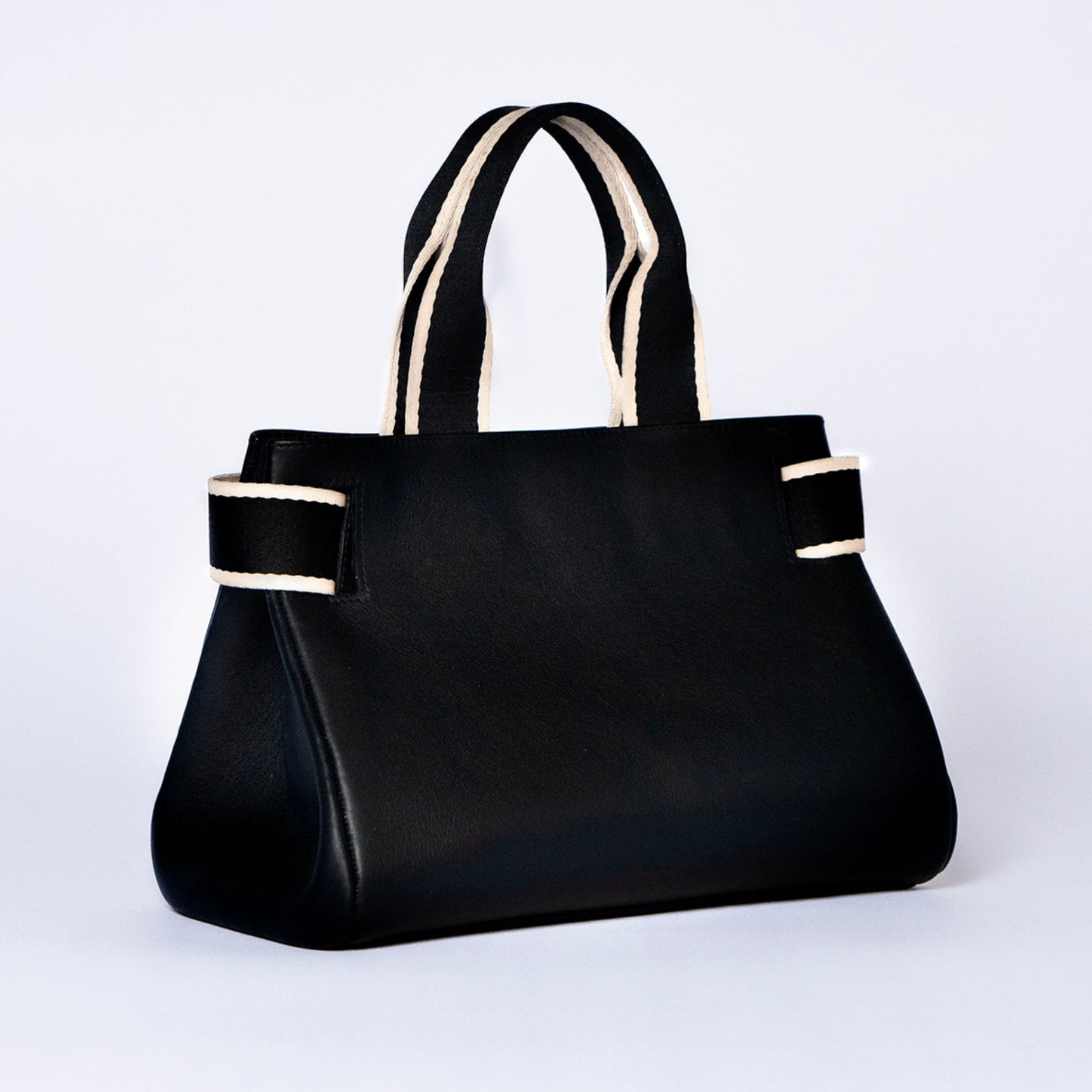 Structured leather handbag — NUMÉRO 04 by atelier &LAB, black upcycled full-grain calf leather, rear three-quarter view showing a clean functional silhouette designed for everyday use.