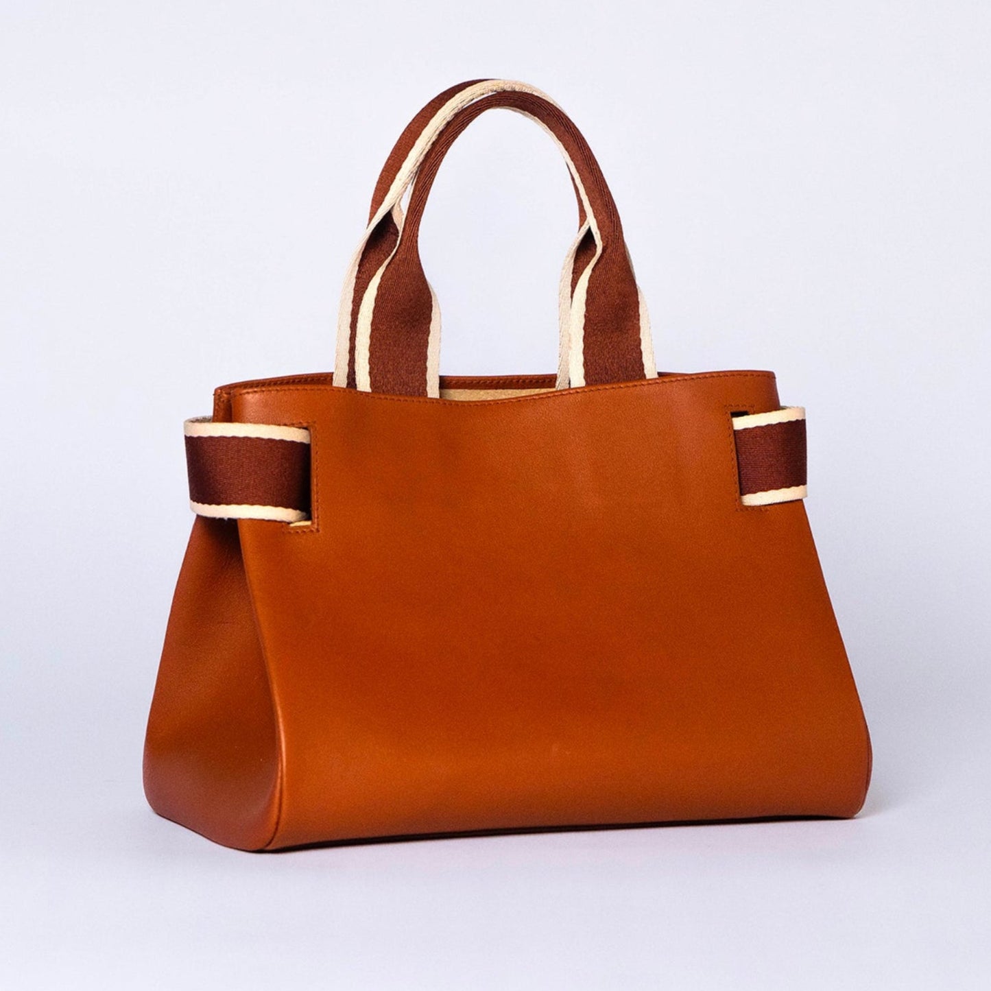 Structured leather handbag — NUMÉRO 04 by atelier &LAB, cognac upcycled full-grain calf leather, rear three-quarter view showing a clean functional silhouette designed for everyday use.