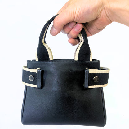 Structured leather handbag — NUMÉRO 04 Mini prototype by atelier &LAB, handheld view showing compact structured volume in use
