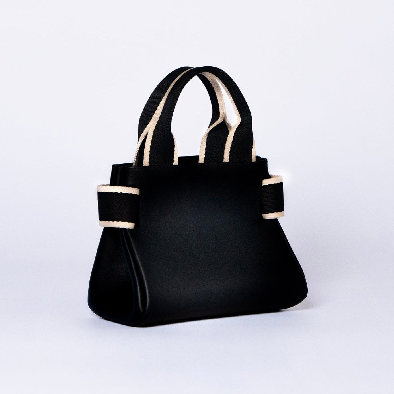 Mini leather handbag in black — NUMÉRO 04 by atelier &LAB, rear three-quarter view, compact graphic shape