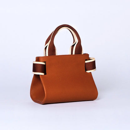 Mini leather handbag in cognac — NUMÉRO 04 by atelier &LAB, rear three-quarter view, compact graphic shape