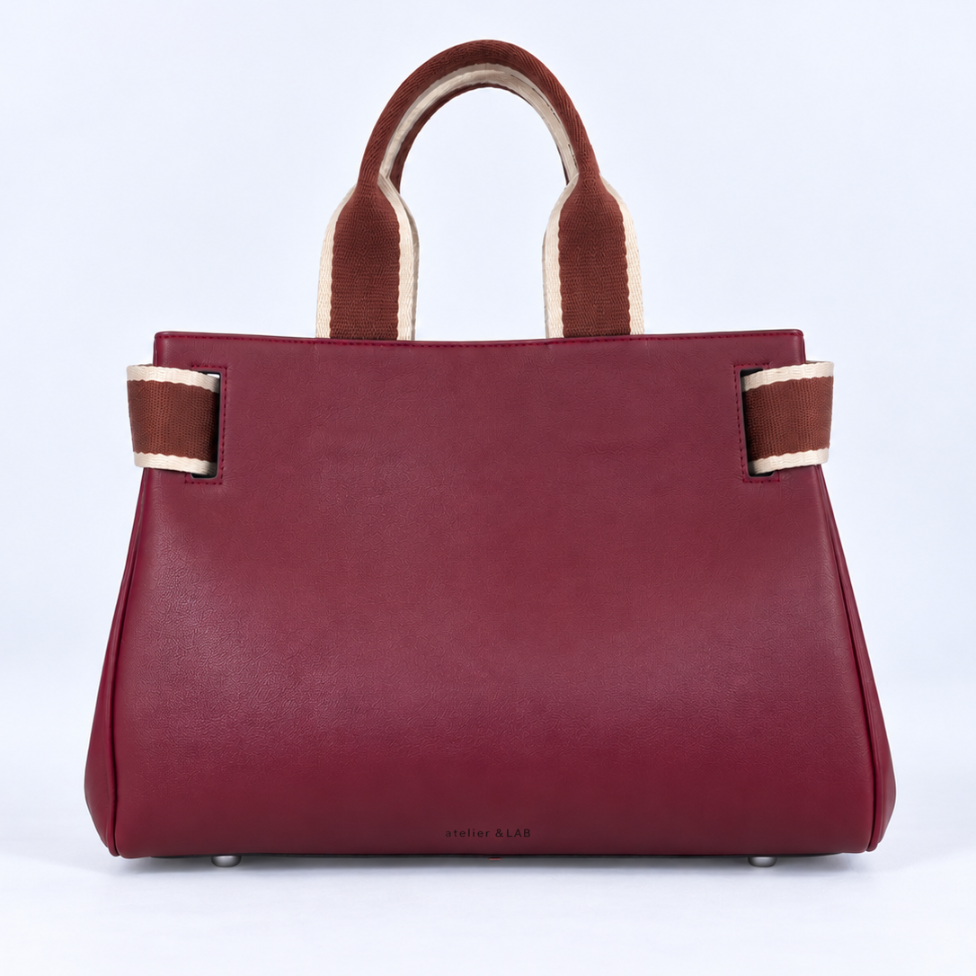 Front view of the NO04 M handbag in Bordeaux upcycled calf leather by Hiroki AMANO — atelier &LAB, featuring contrasting rust and ecru woven handles, softly structured sides and a discreet embossed logo. Designed and made near Paris.