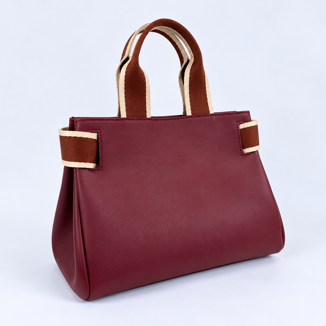 Three-quarter view of the NO04 M handbag in Bordeaux upcycled calf leather by Hiroki AMANO — atelier &LAB, showing its softly structured silhouette, folded sides and contrasting rust and ecru woven handles. Designed and made near Paris.