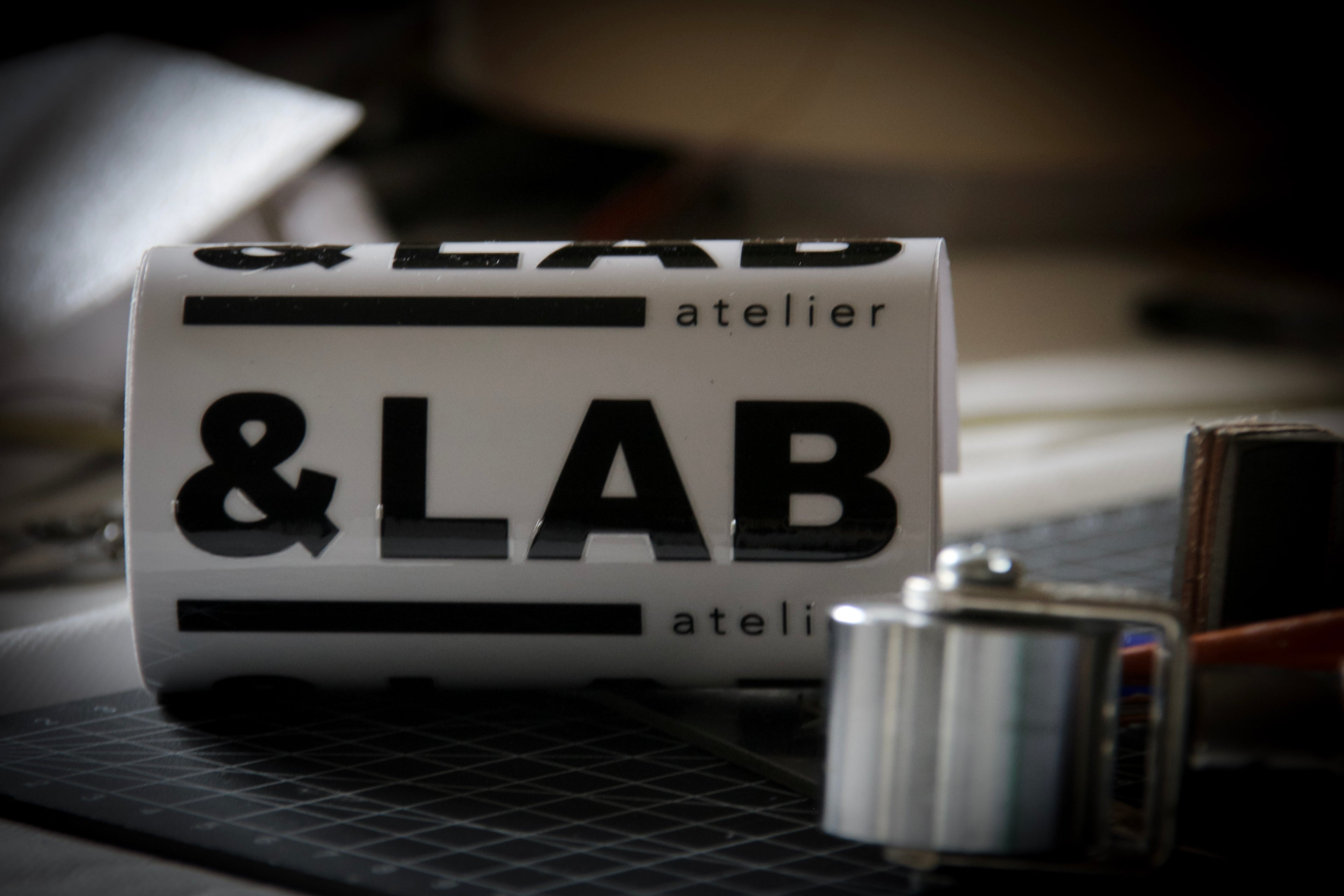 Technical assembly at the &LAB studio — steel edge roller and graphic marking elements, highlighting a rigorous design process and structural precision, Paris.